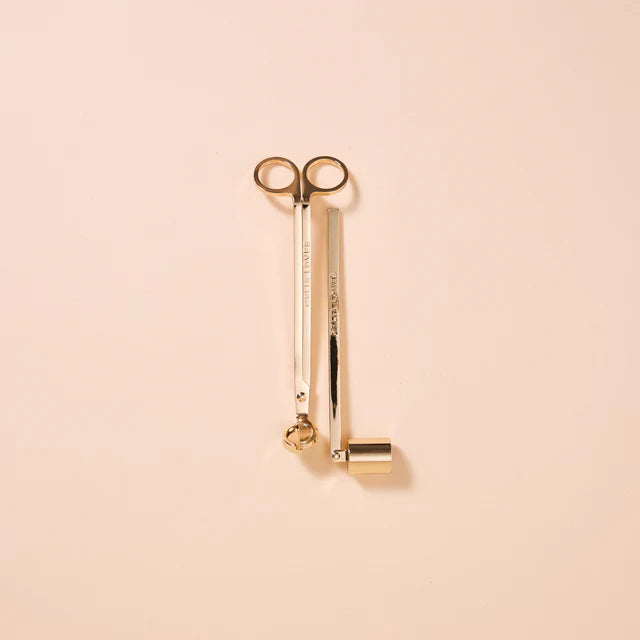 Gold candle tools on a beige background