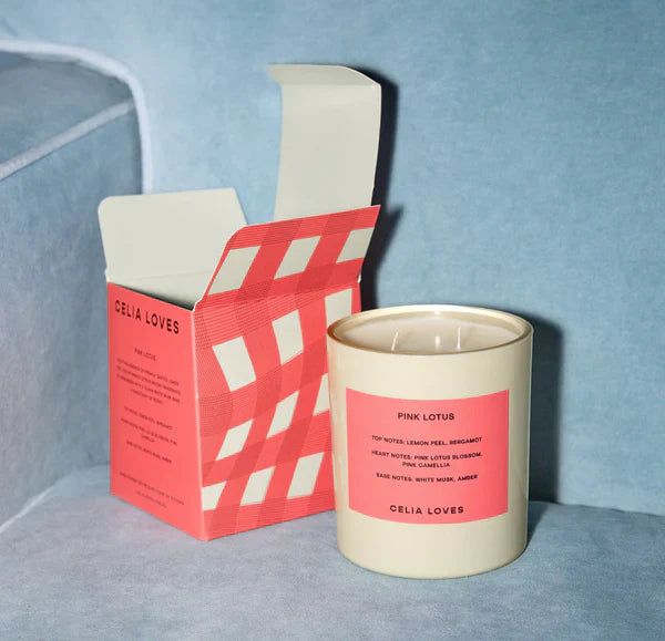 Celia Loves pink lotus candle and box against a blue background