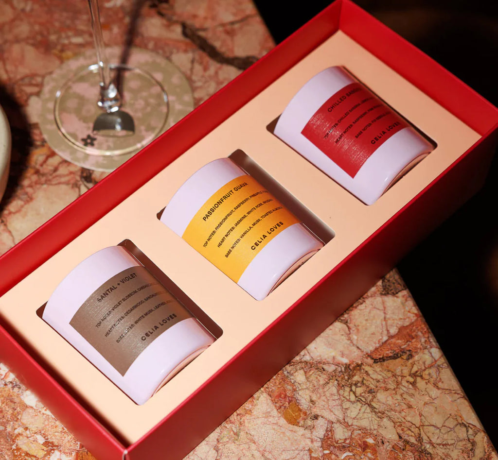 Set of three cylindrical candles with labels in a red box on a map background