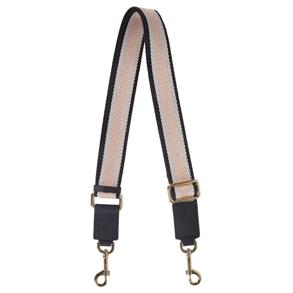 A white background with thick black and blush striped, cotton fabric bag strap with gold hardware and clips on the end.