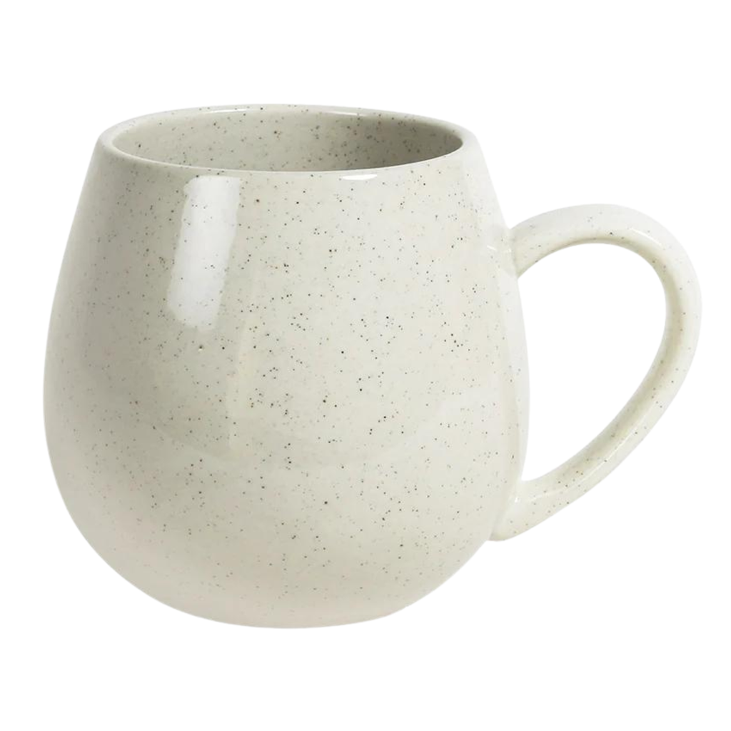 A rounded shape off white mug with black speckles and a handle on a white background