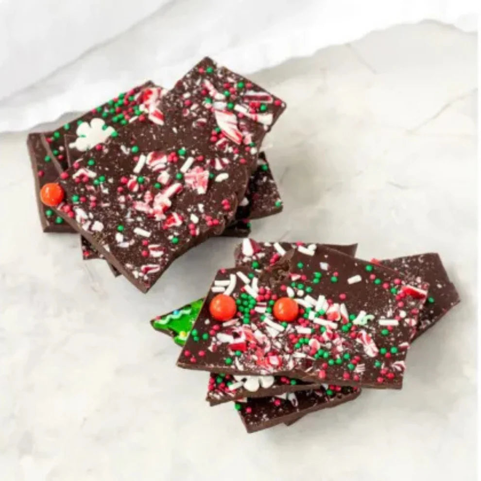 Chocolate bark with festive sprinkles on a white surface