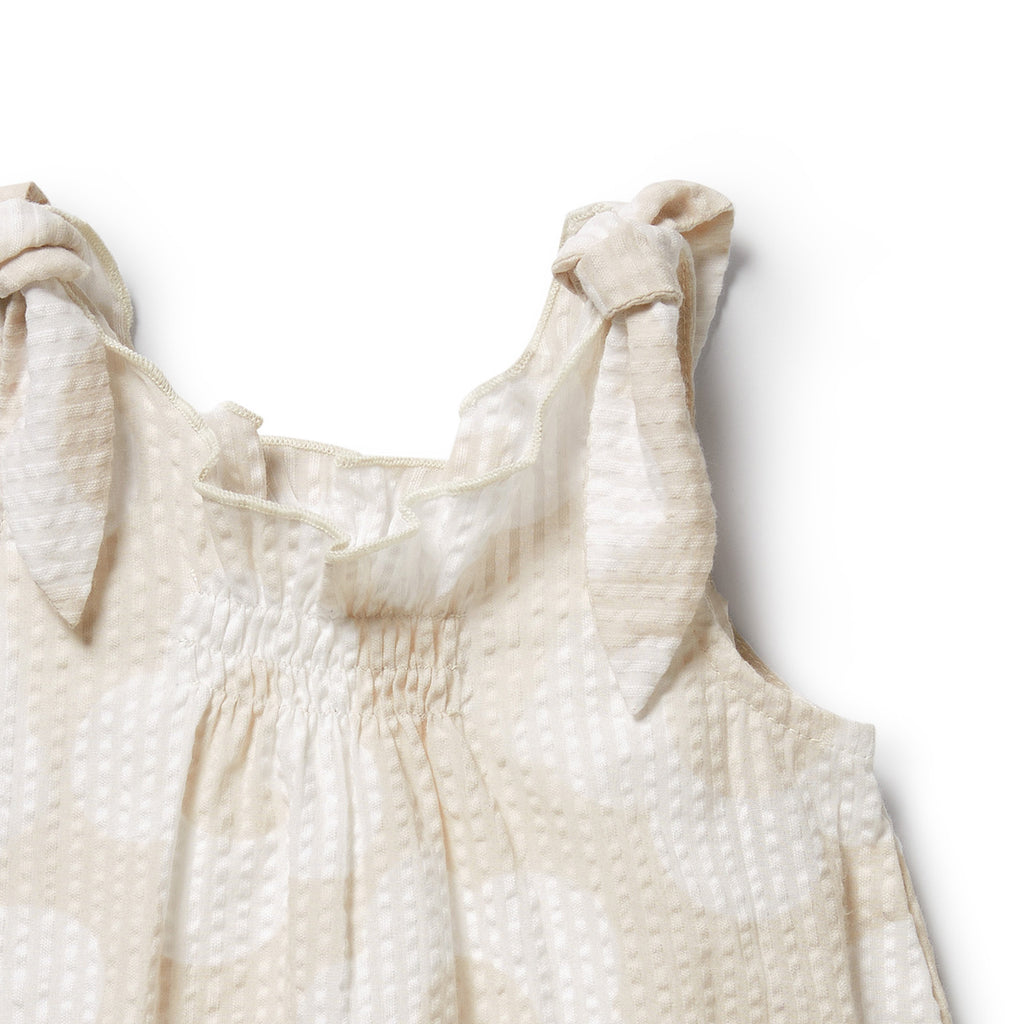 Beige sleeveless top with knot details on a white background