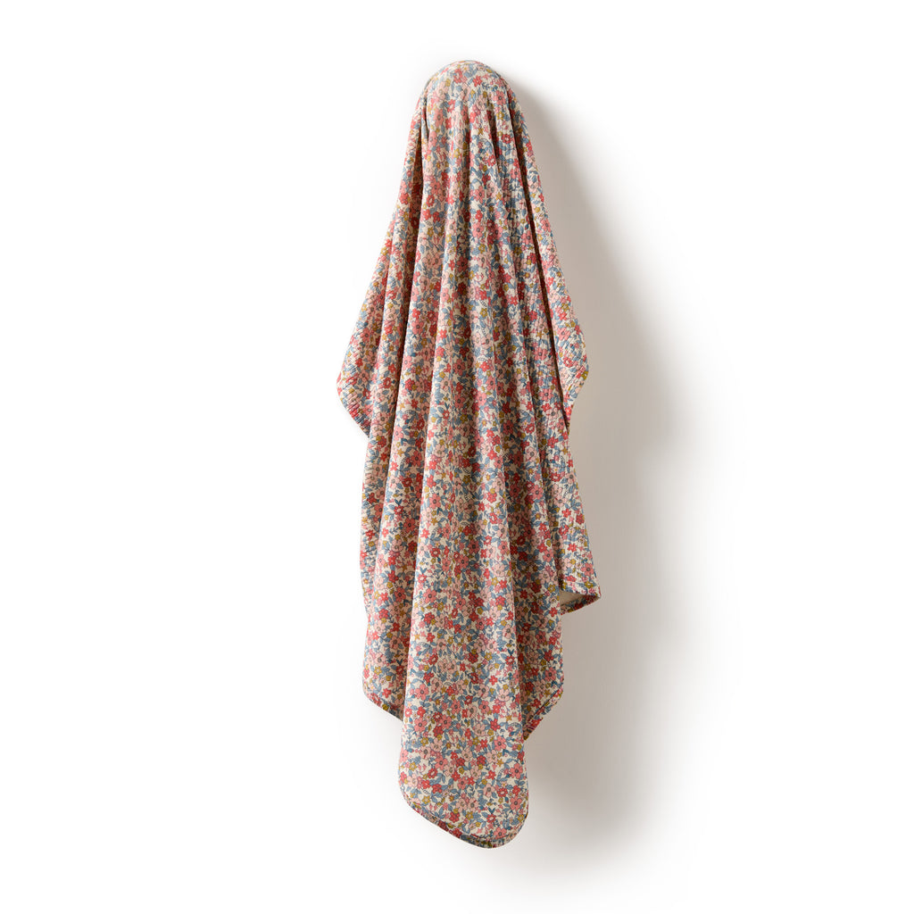 Floral patterned blanket draped on a white background