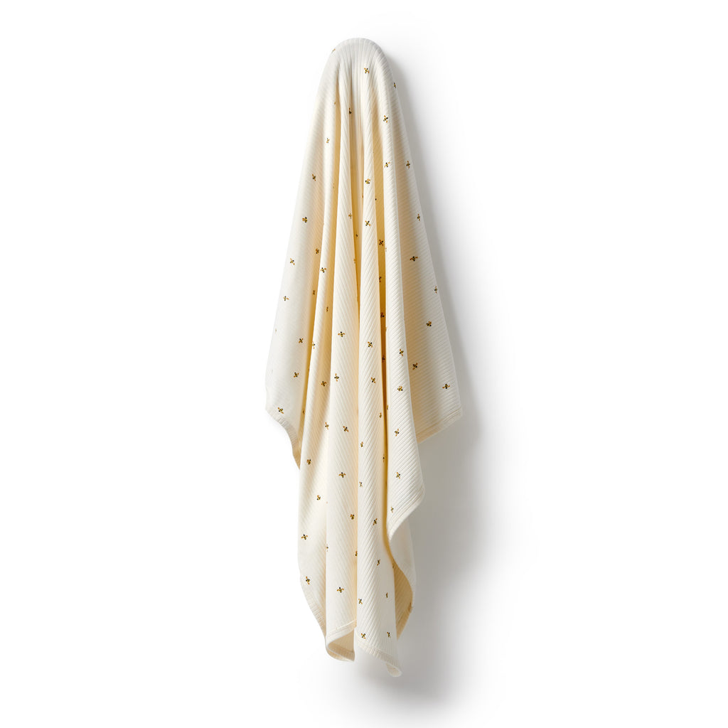 Beige towel with small patterns draped over a white background