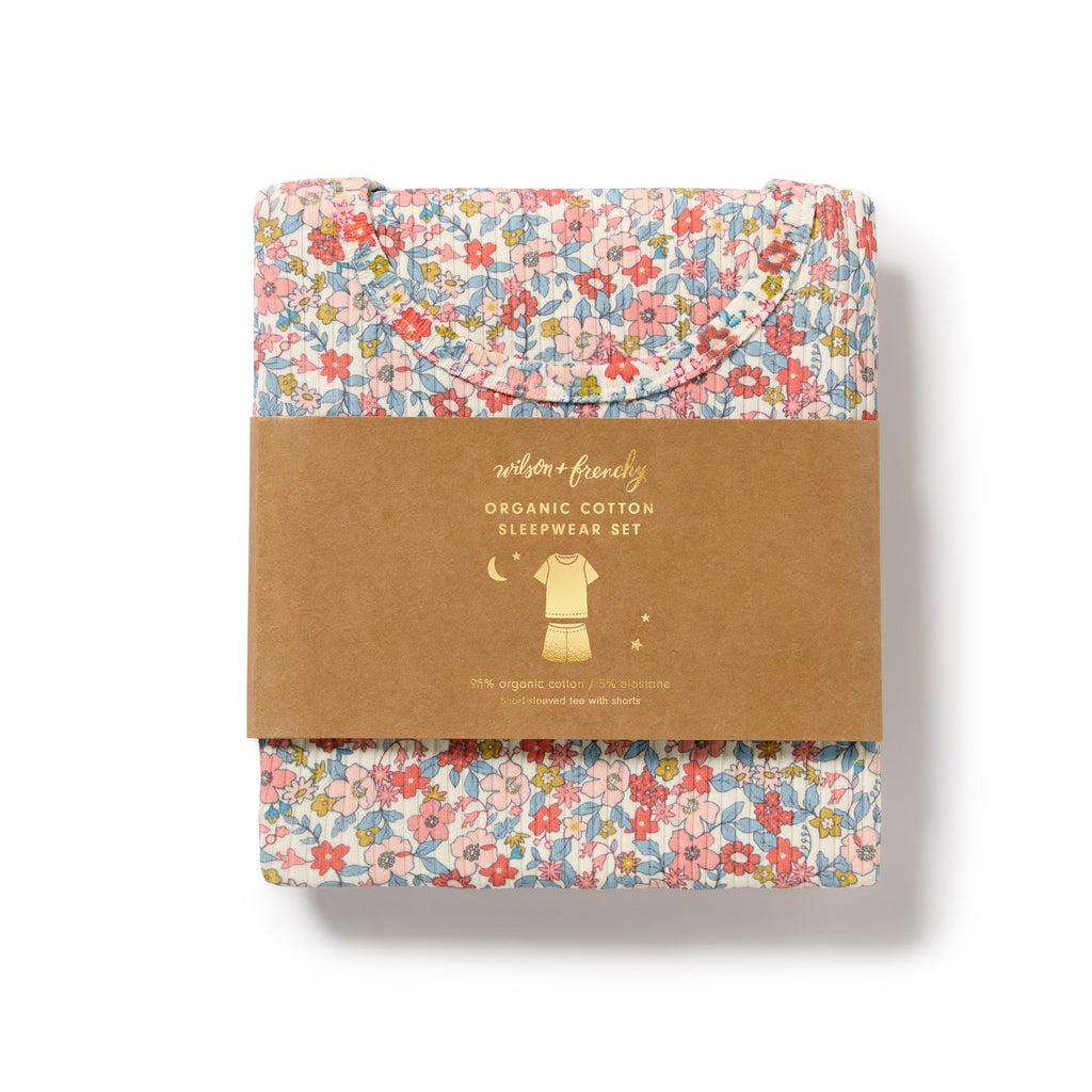 Folded organic cotton sleepwear set with floral pattern on a white background