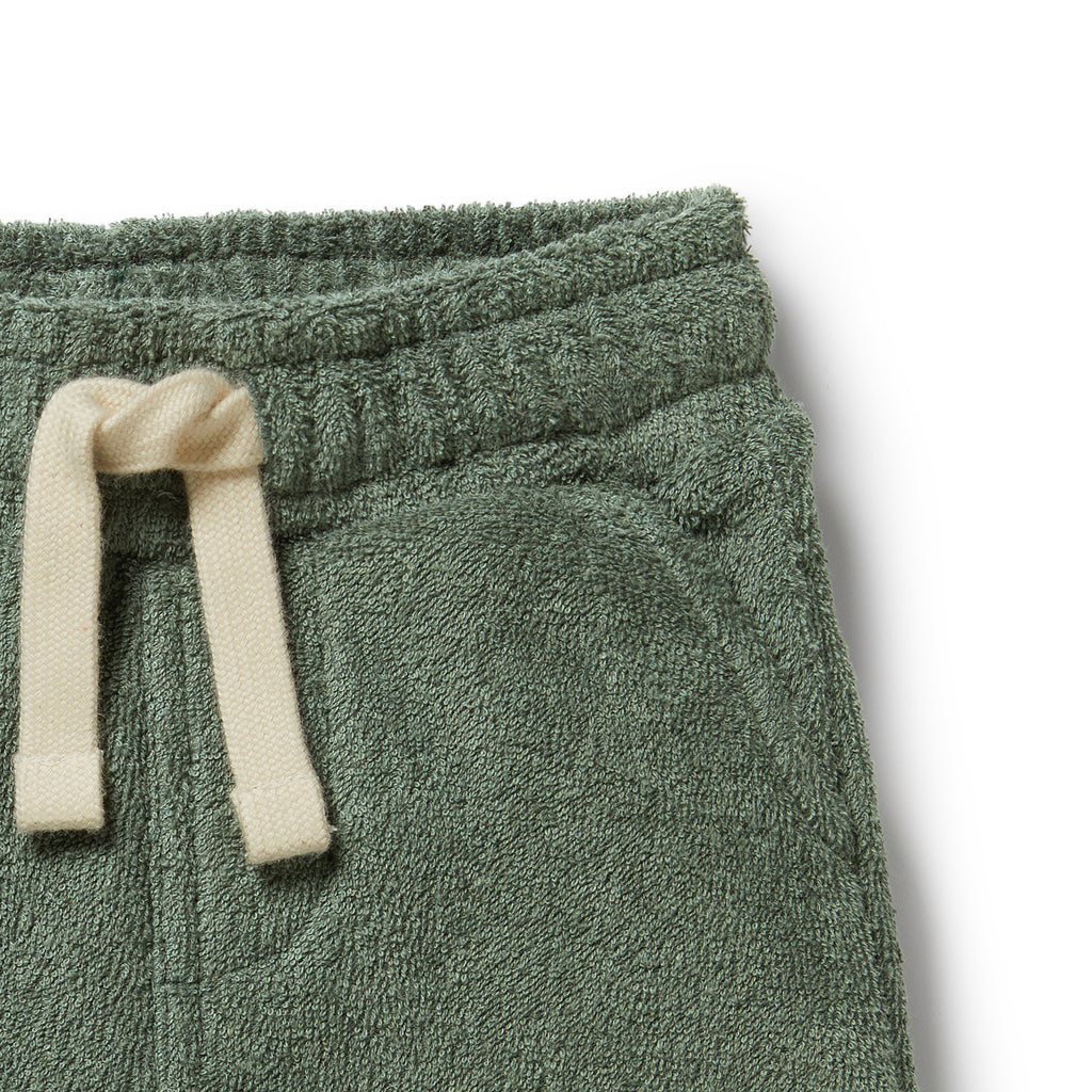 Green fleece pants with a cream drawstring on a white background