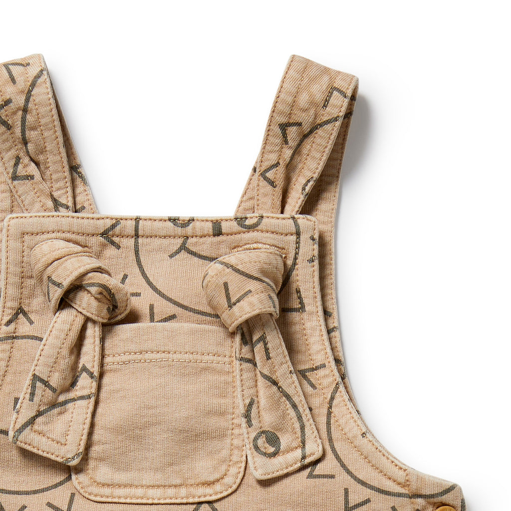 Beige children's overalls with black geometric patterns on a white background