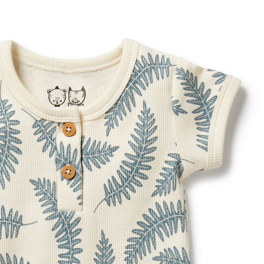 Baby romper with fern leaf pattern and wooden buttons on a white background