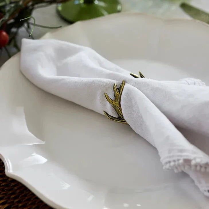 White napkin with a decorative metal clip on a white plate
