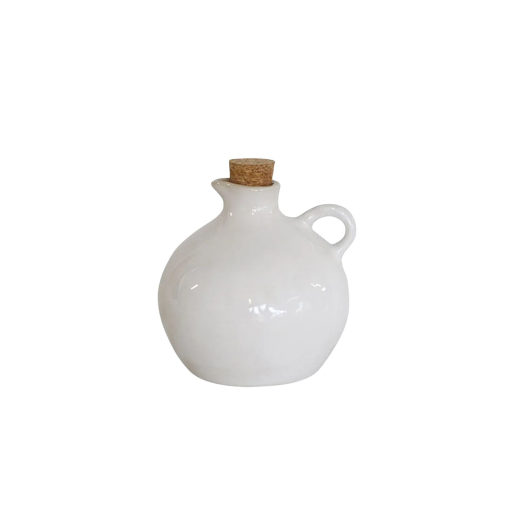 White ceramic oil jar with cork lid on a white background