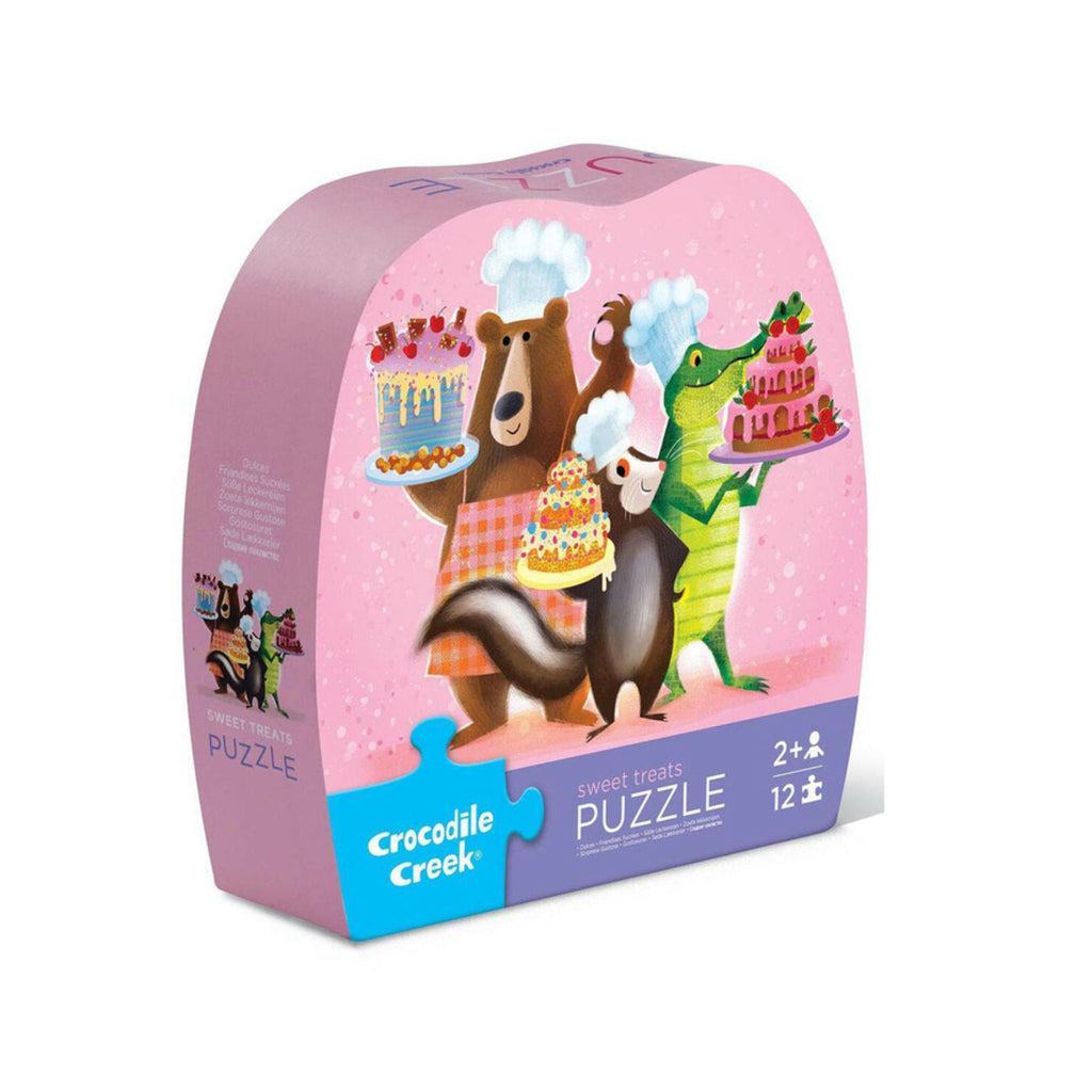 Crocodile Creek puzzle box with cartoon animals around a cake on a pink background