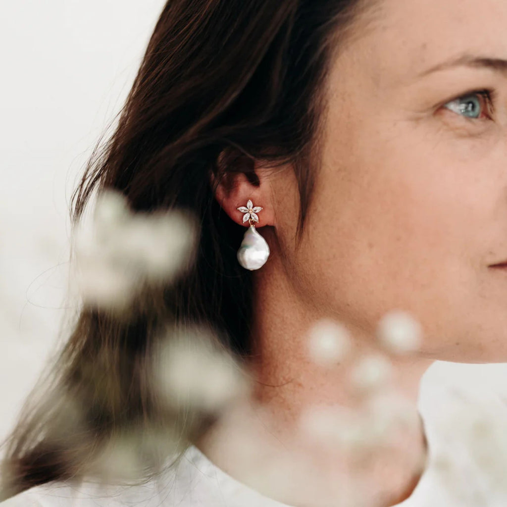 Close-up of a woman wearing a floral earring with a blurred background