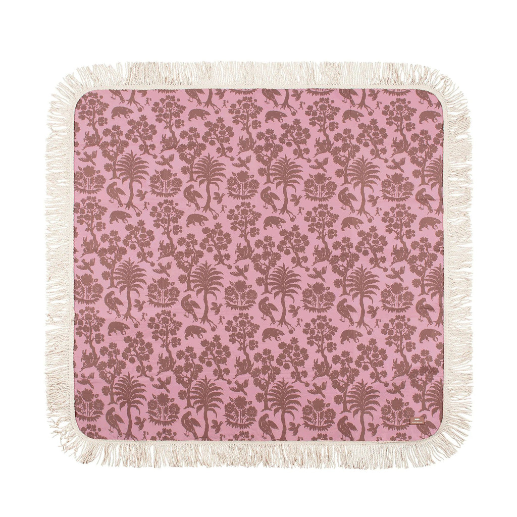 Pink floral patterned blanket with white fringe on a white background
