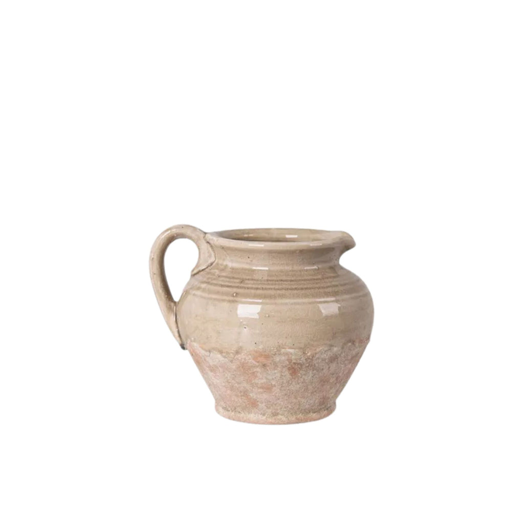 Beige ceramic pitcher on a white background