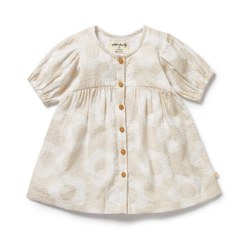 Beige baby dress with button details on a white background