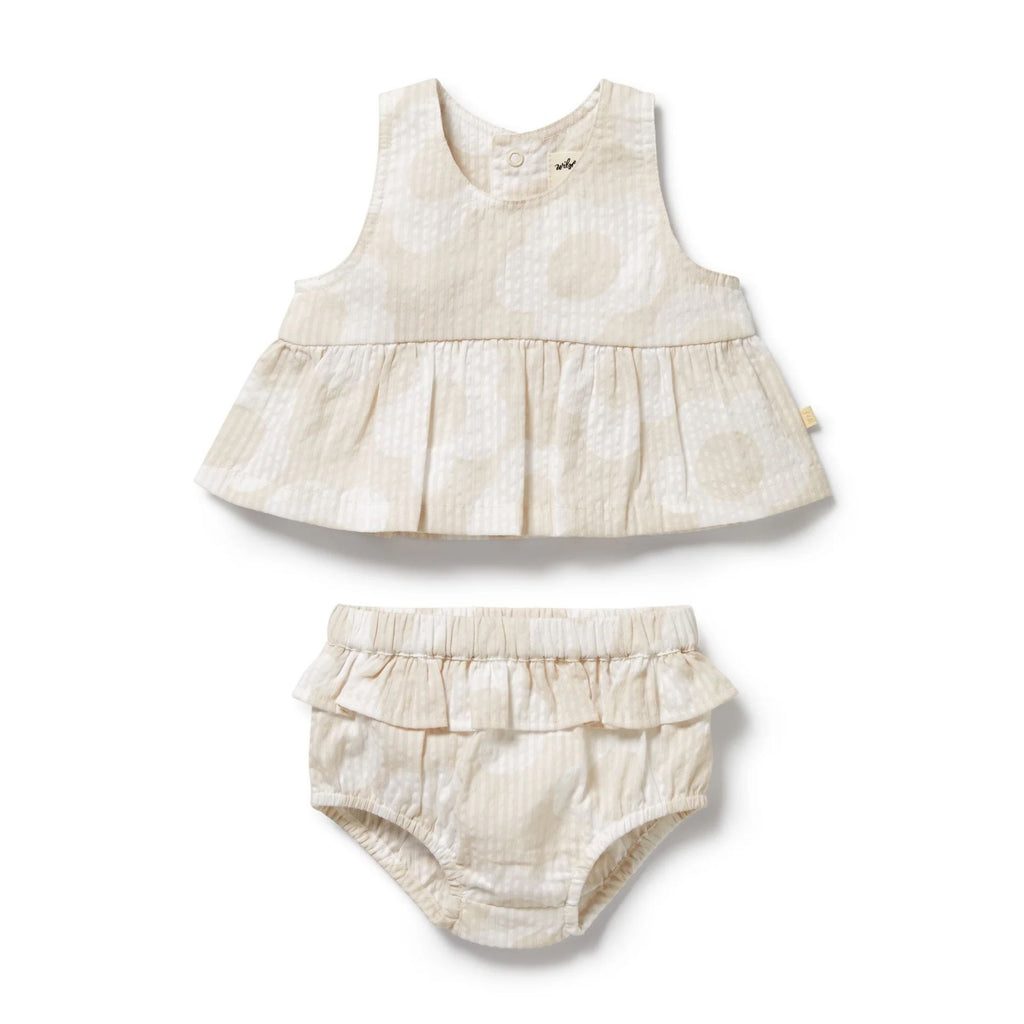 Baby dress and bloomers set with ruffled details on a white background