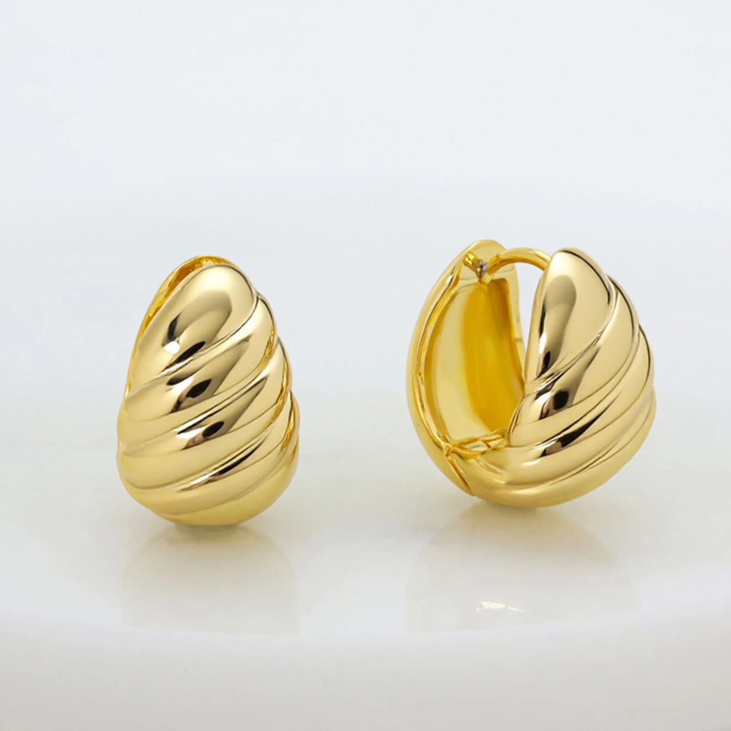 Pair of gold hoop earrings on a light gray background