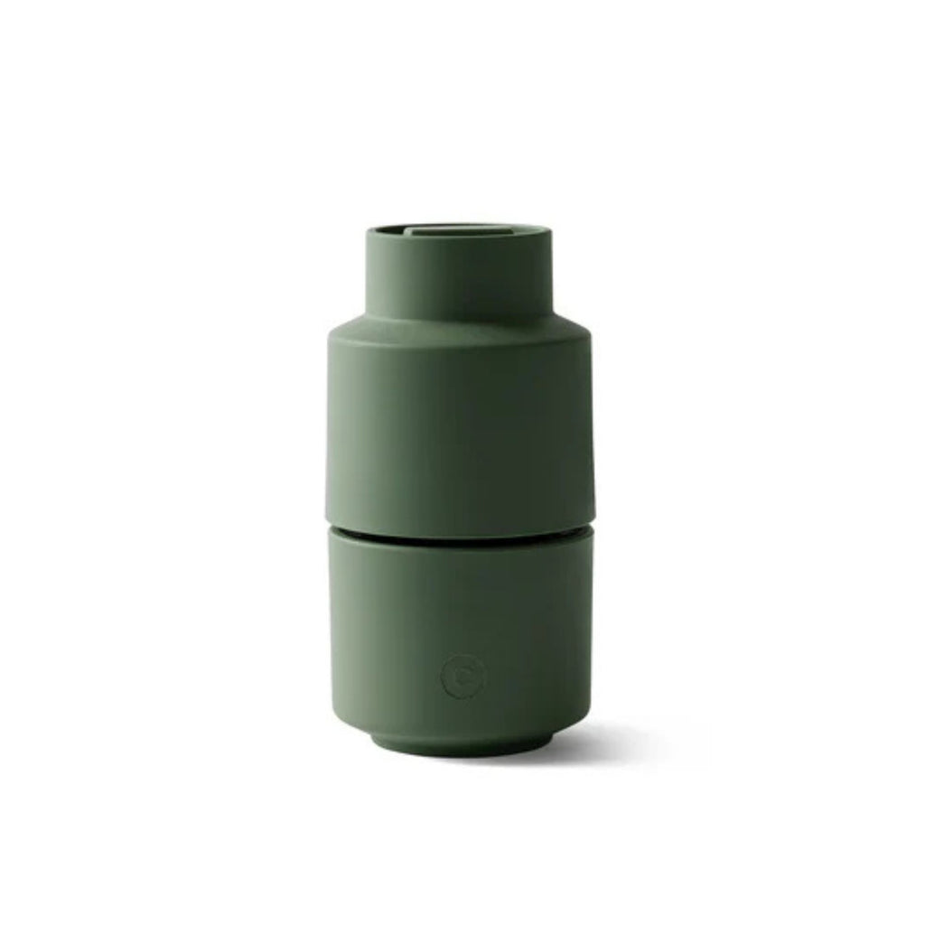 Green cylindrical salt grinder on a white background