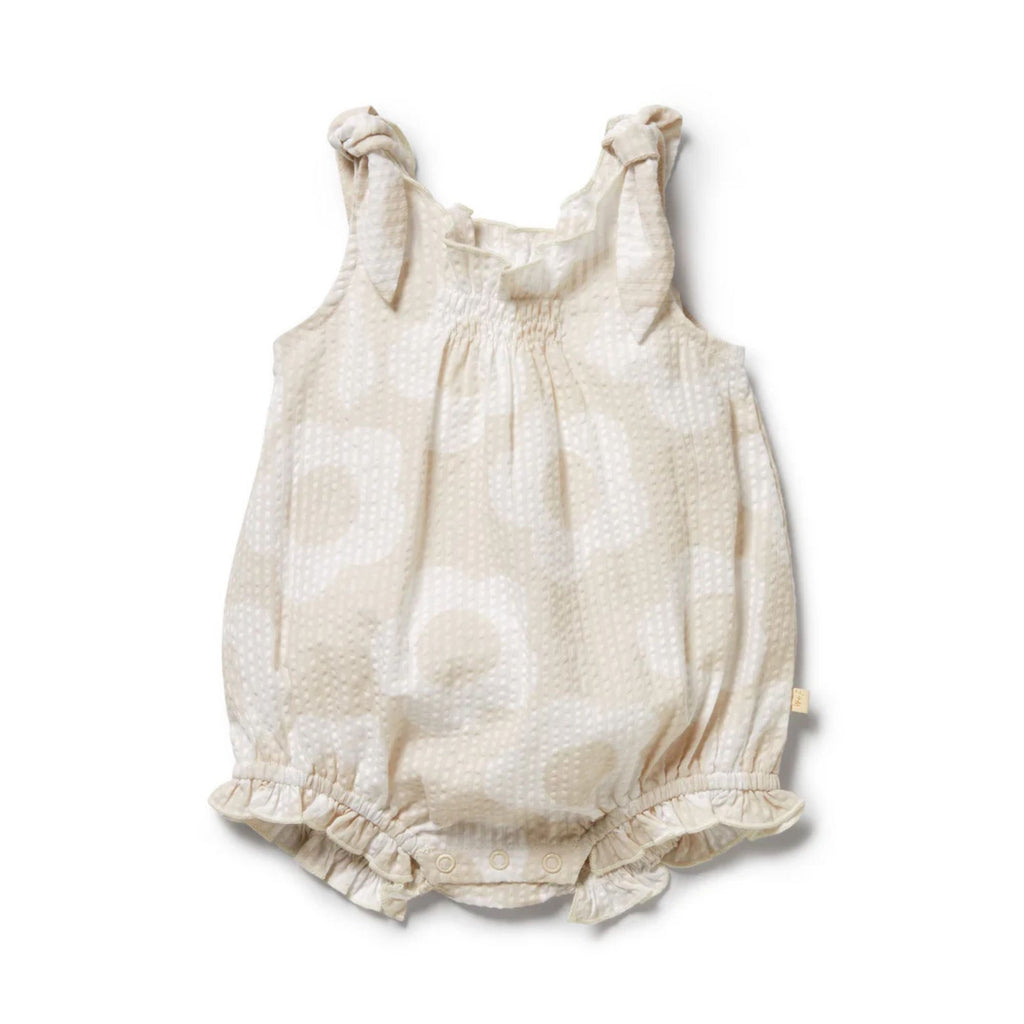 Beige baby romper with knot straps on a white background