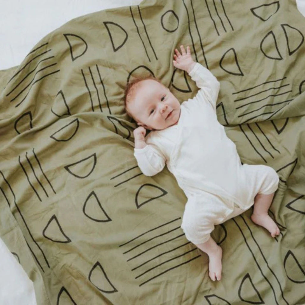 Baby lying on a patterned blanket