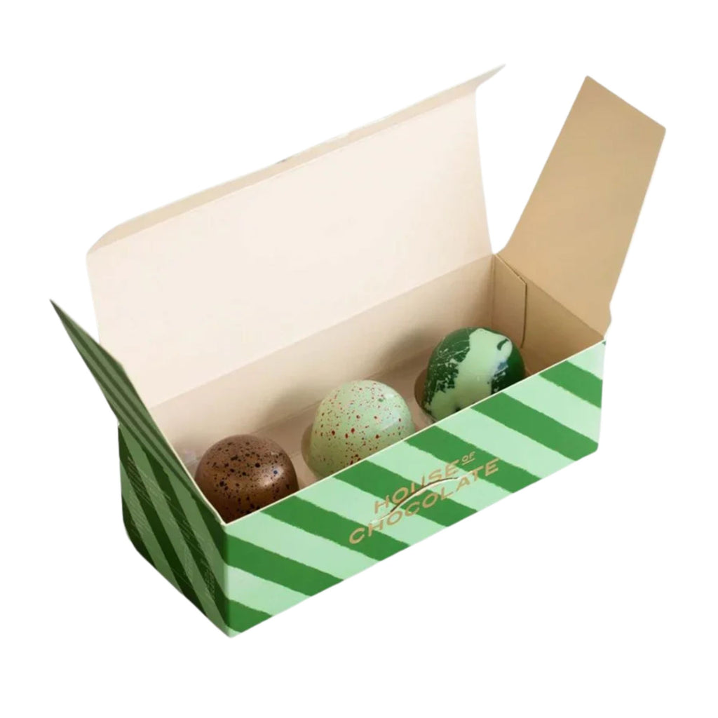 Open box with green and white striped design containing three chocolates on a white background