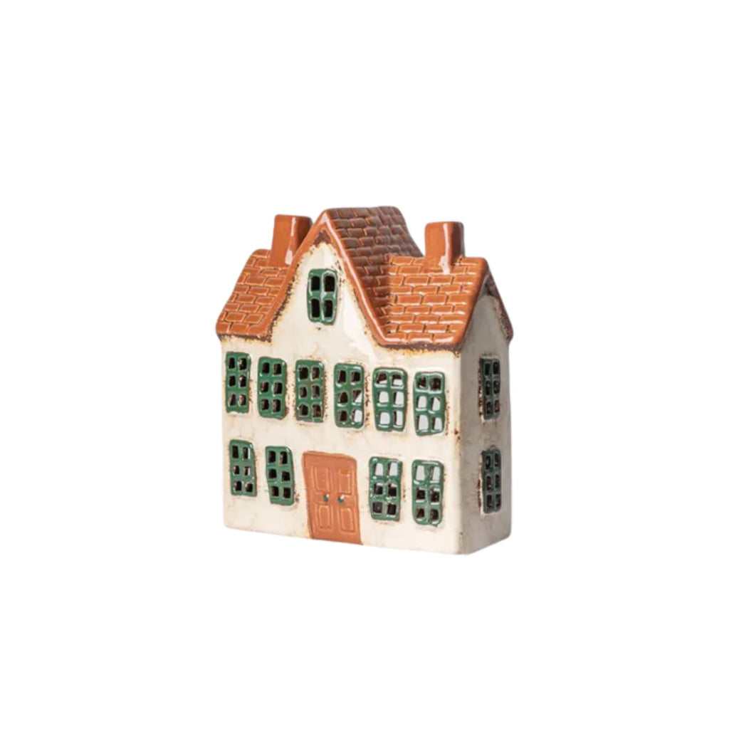 Small ceramic model of a house with a brown roof and green windows on a white background