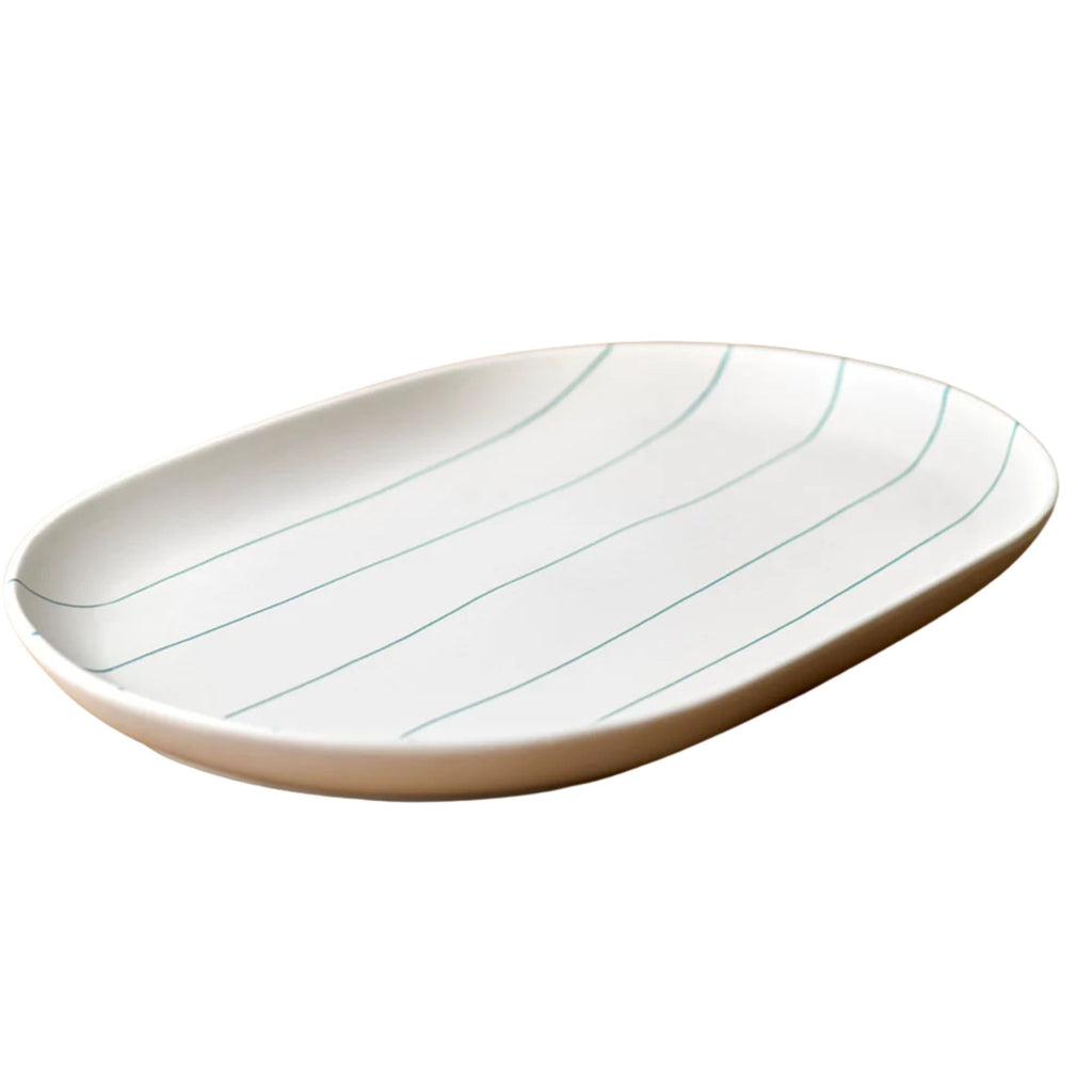 White ceramic plate with green lines on a white background