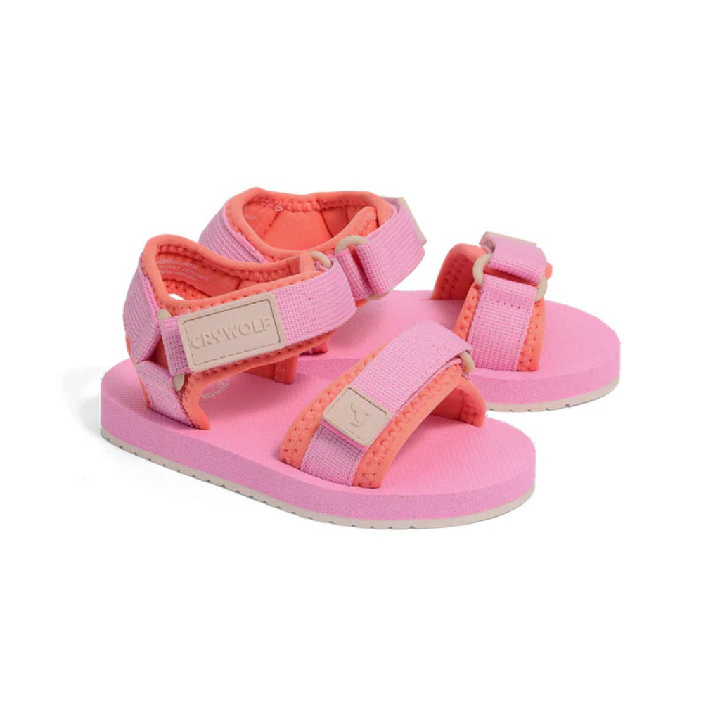 Pink and coral children's sandals on a white background