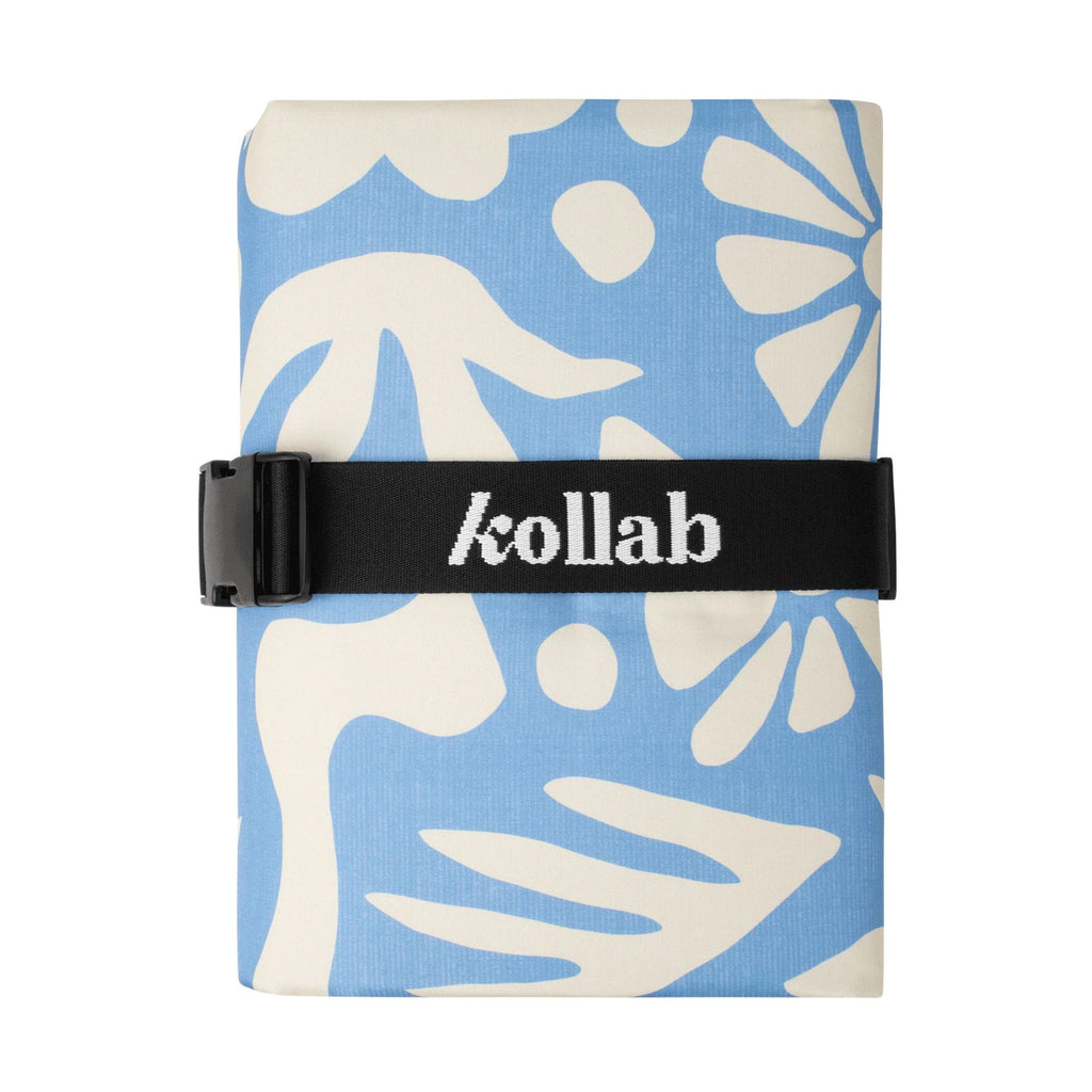 Folded mat with blue and white leaf pattern and 'kollab' branding on a black strap.