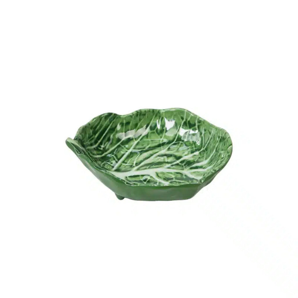 Green ceramic bowl shaped like a leaf on a white background
