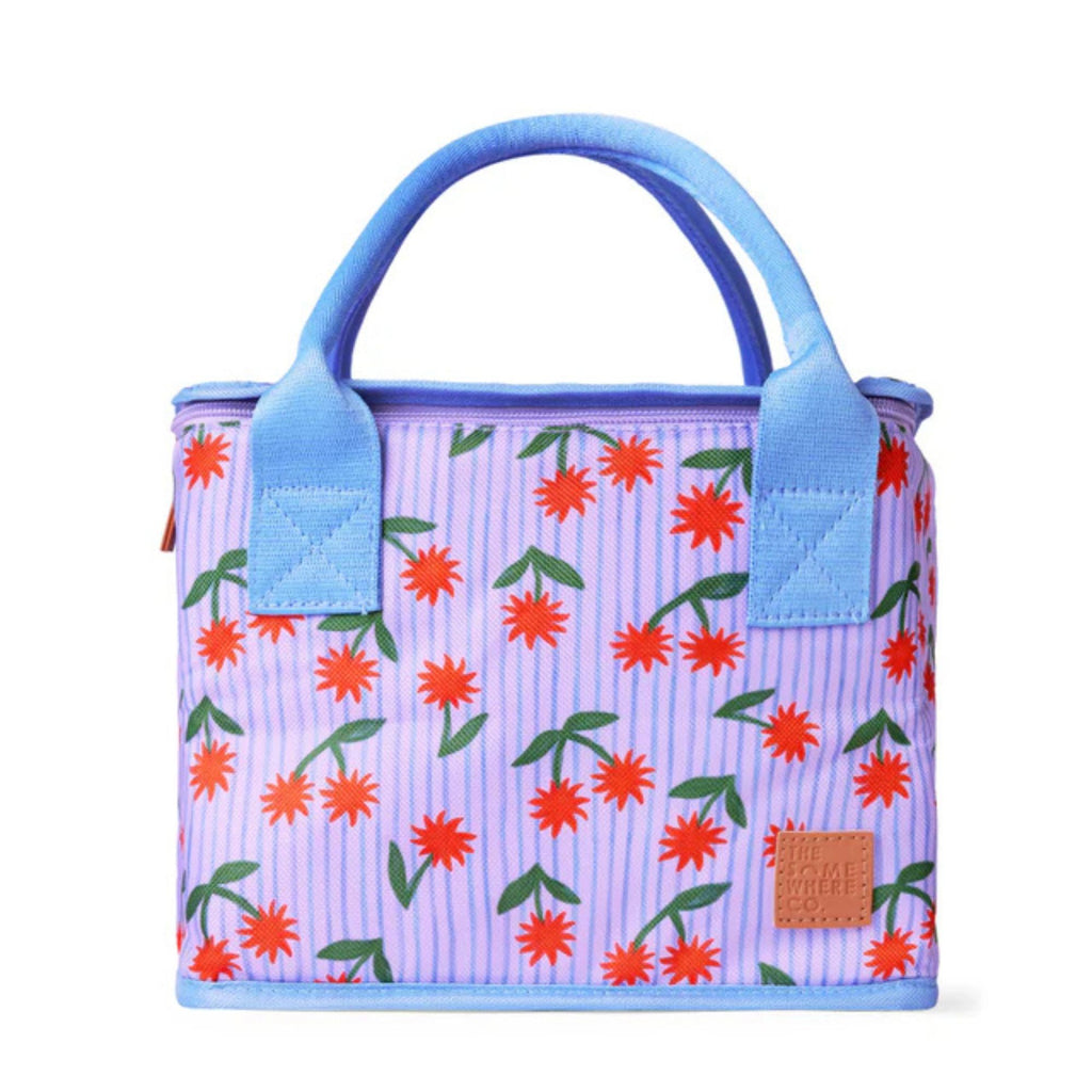 Floral patterned bag with blue handles on a white background