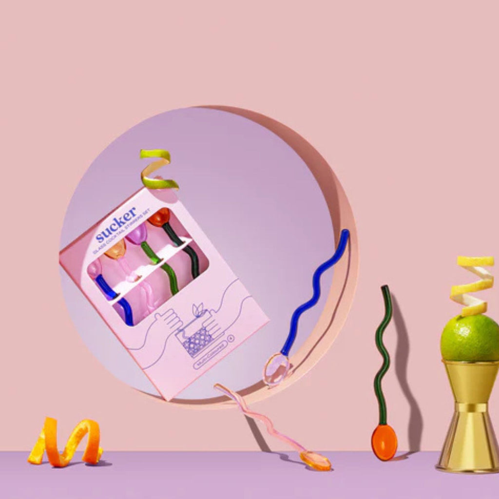 Colorful novelty items including a box labeled 'Sucker' on a pink background