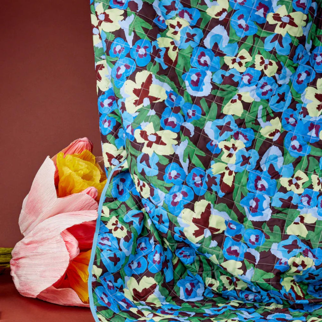 Colorful floral-patterned fabric with a pink tulip in the background