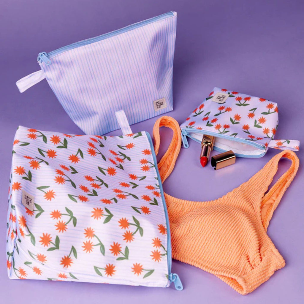 Floral-patterned pouches and an orange bra on a purple background