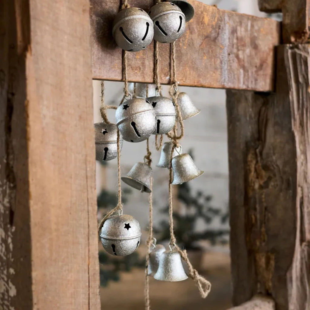 Vintage-style metal bells hanging on a rustic wooden door