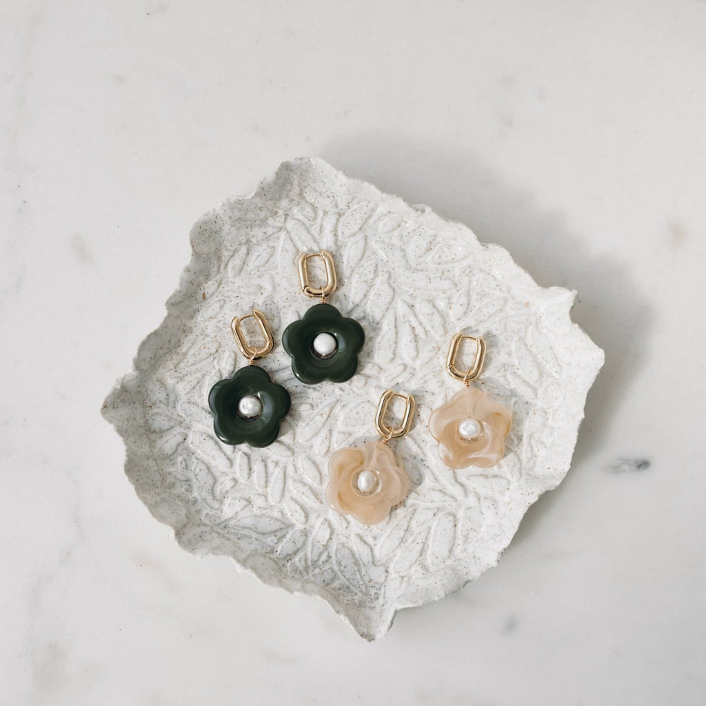 Pair of floral earrings on a textured white surface