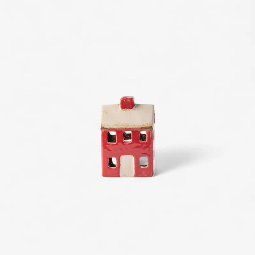 Small ceramic house with a red roof on a white background