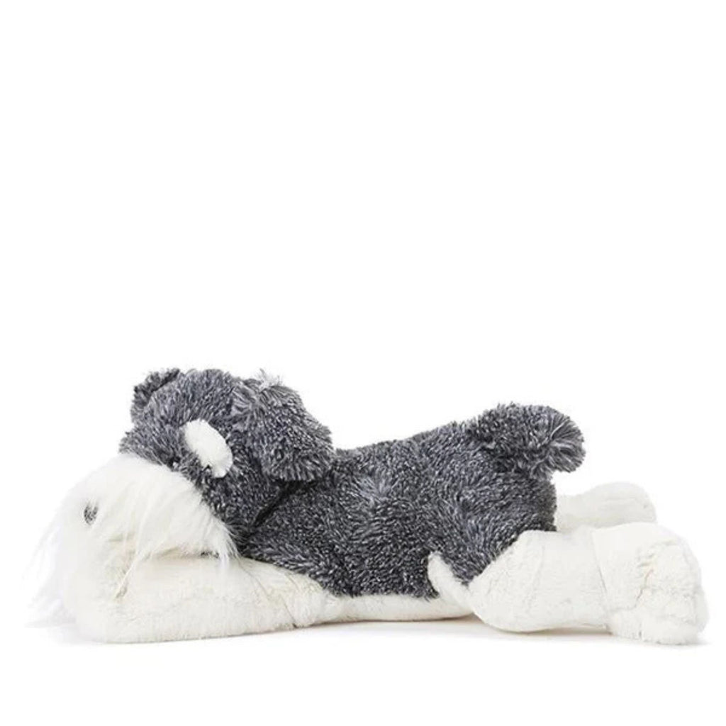 a soft toy grey and white dog lying on his stomach against a white background
