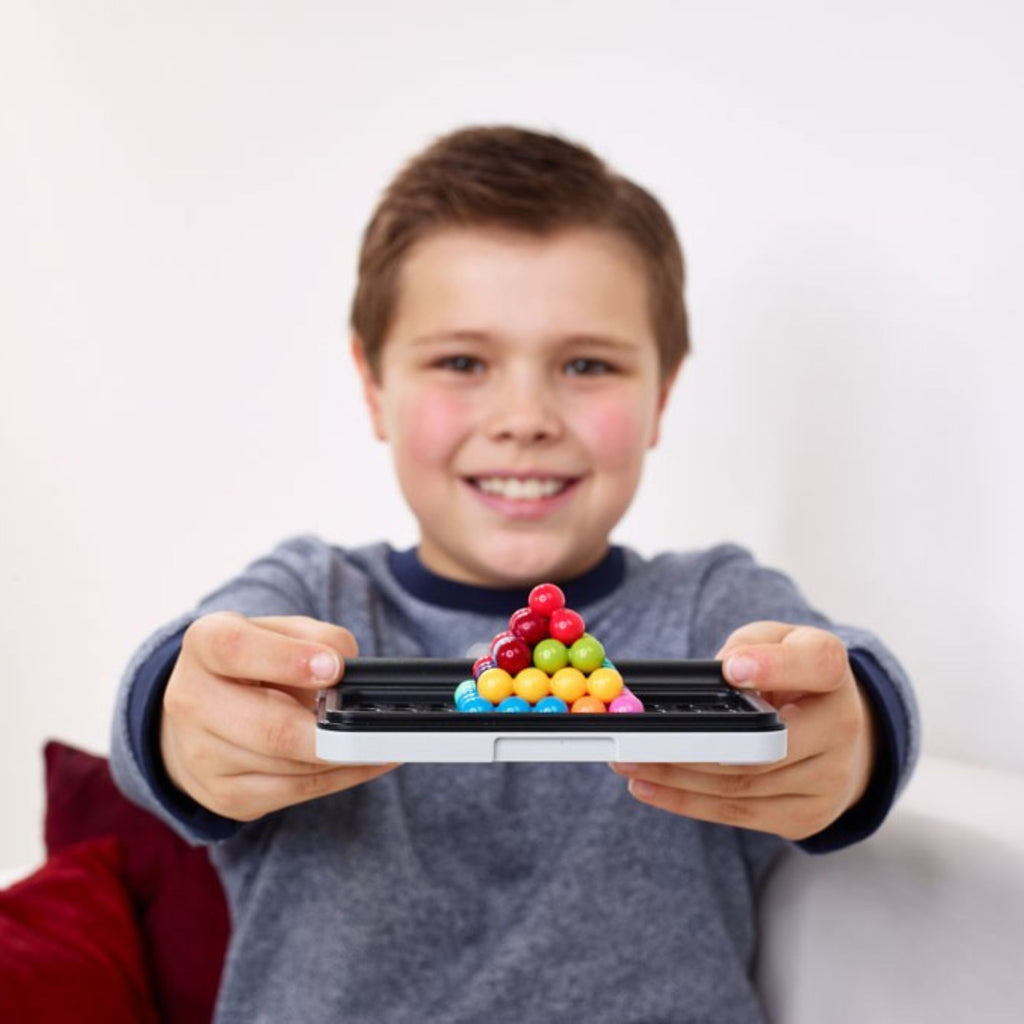Child holding a smartphone with colorful candy on a white background