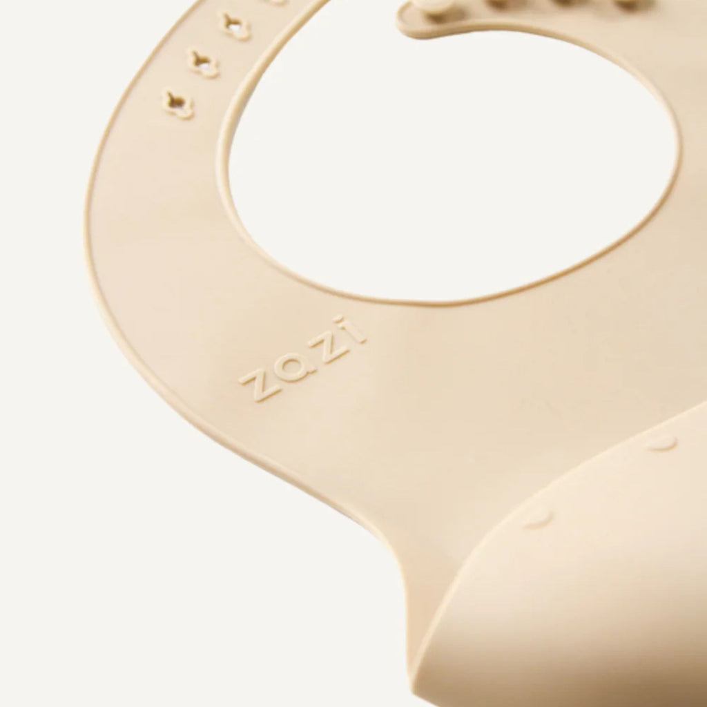 Beige silicone teether with 'zazi' branding on a white background