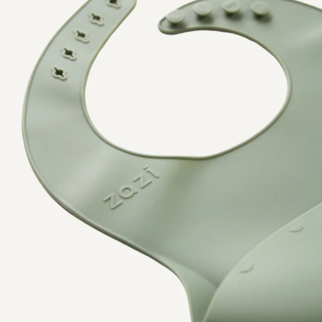 Green silicone bib with 'zazi' branding on a white background