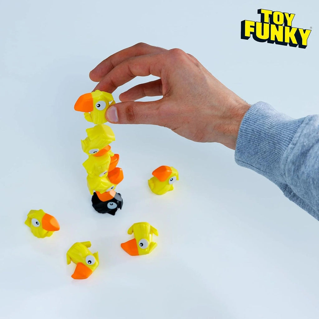 Hand arranging colorful toy ducks on a white surface with 'Toy Funky' branding.