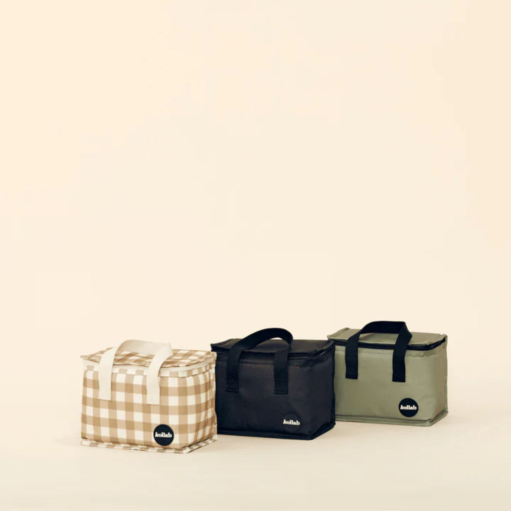 A set of three lunch bags in khaki, black and white and tan check against a cream background