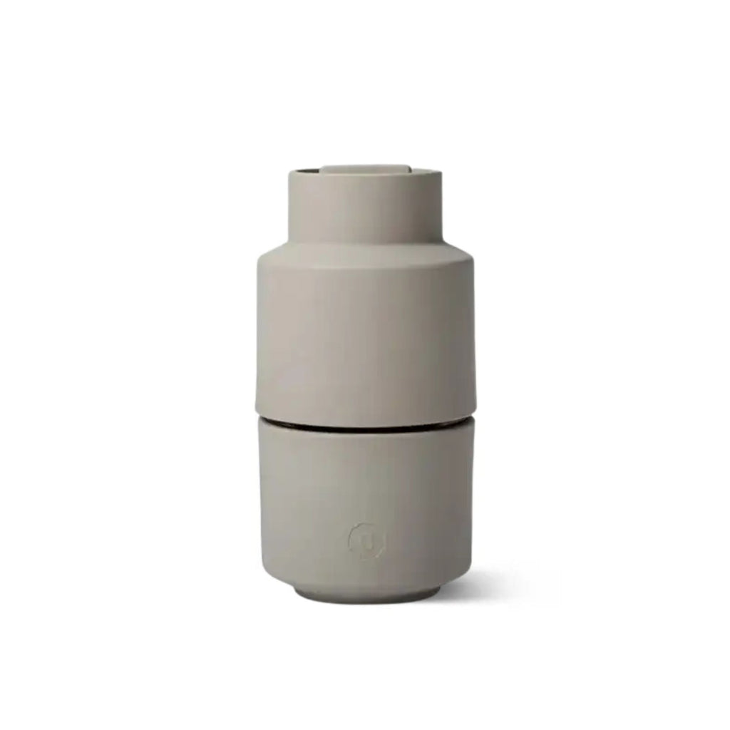 Beige ceramic salt grinder on a white background