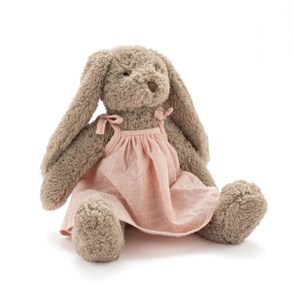 A plush toy rabbit wearing a baby pink dress against a white background