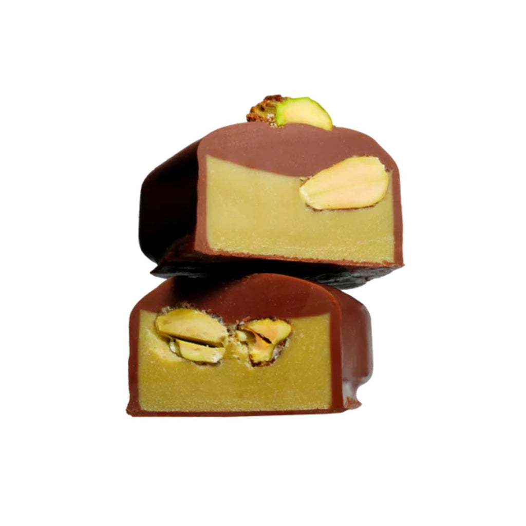 Two chocolate-covered treats with pistachio filling on a white background