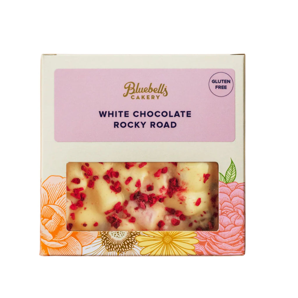 Packaged white chocolate rocky road with visible red berries, branded as Bluebells Bakery on a white background.