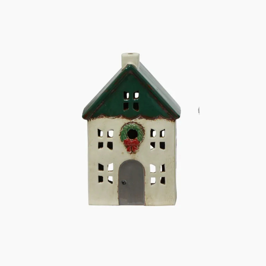Decorative house-shaped ornament with a green roof and wreath on a white background