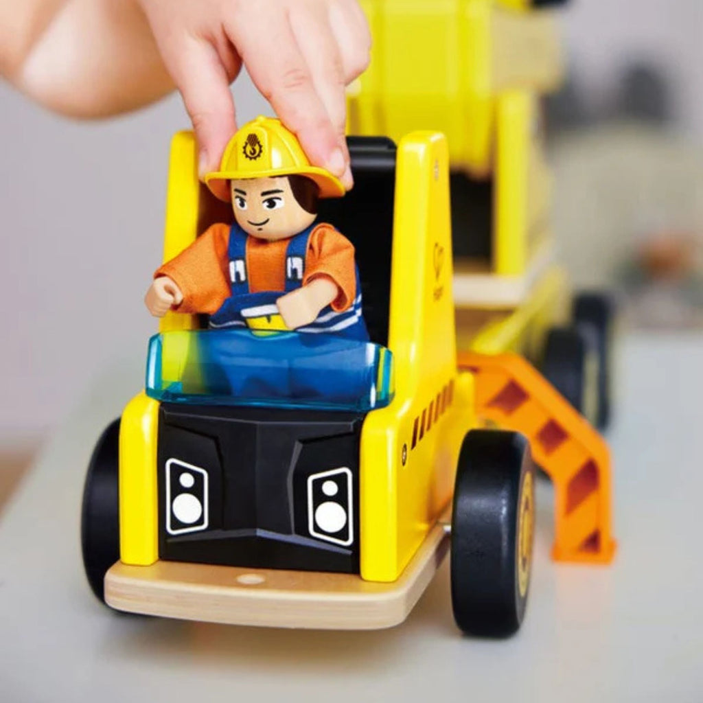 Toy construction vehicle with a figure of a construction worker on a blurred background
